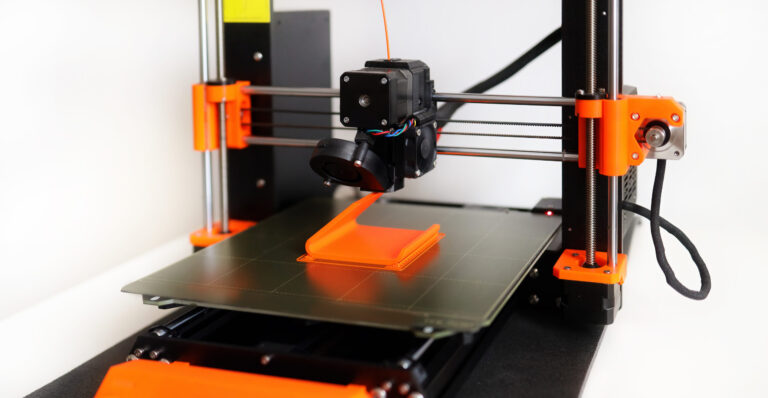 FDM 3D Printer printing orange 3D object.