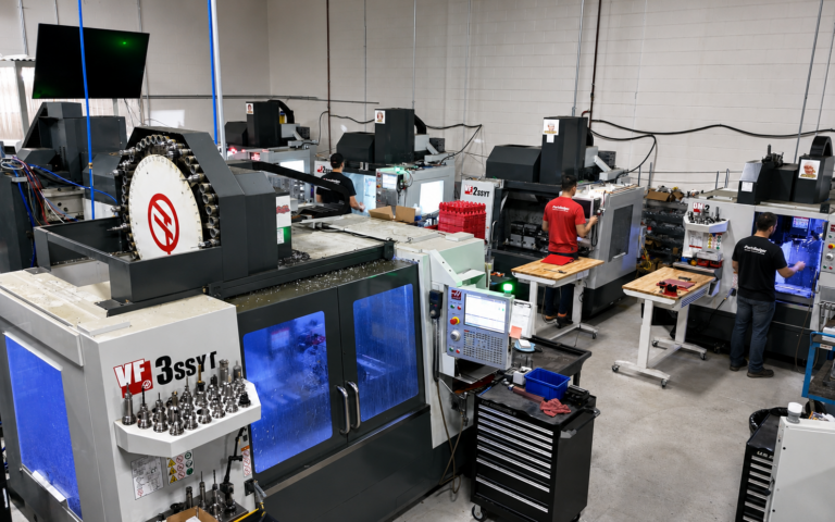 Overhead view of the PartsBadger CNC shop floor with machining centers and team members operating production equipment